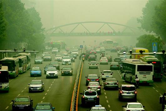 图为：6月12日下午，武昌武珞路，不少汽车开启了车灯。当日，武汉遭雾霾侵袭，空气严重污染。（记者 倪娜 摄）