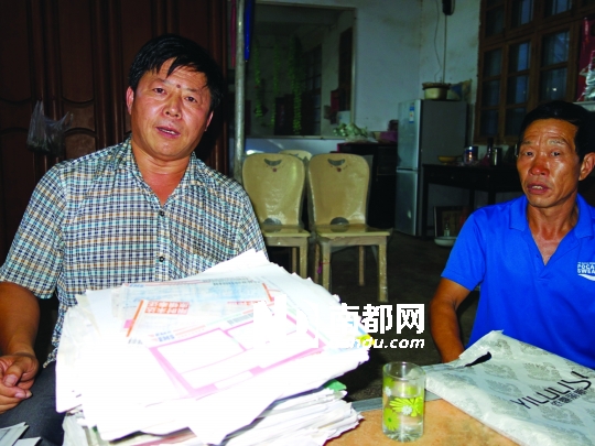 尹照宾(左)和牛根占几年来积攒的部分申诉材料。    南都记者 孙旭阳 摄

