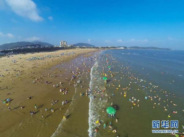 7月30日,游客在舟山市普陀区朱家尖南沙景区的海滩上休闲戏水.