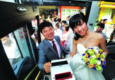 新郎新娘刷卡坐公交。记者李子云陈亮摄(来源:武汉晨报) 