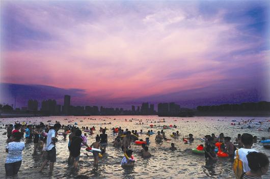 图为：昨日19时，龙王庙水域挤满了消暑的市民