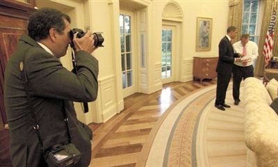 索萨正在拍摄奥巴马与官员交谈。