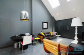 这是英国的一间简约风格的Loft，展现了客厅、厨房等一系列的的室内设计，大体上运用了黑、白、灰三种色调，适当地添加了颜色明亮的小物件，如明黄的抱枕、粉红的坐垫加以点缀。让人眼前一亮，简约而不简单。