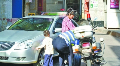 女子带孩子下车后动手，将执法交警摁弯了腰。