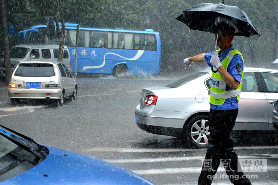 青岛市区骤雨突降交通堵塞 交警冒雨指挥交通