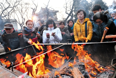 1月31日，雍和宫，几位香客在香炉前点香。昨日全天共有7.6万人到雍和宫上香，比去年同期增加5000多人。（来源：新京报网）