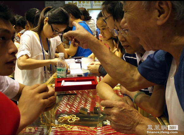 2013年6月23日，广州金交会上，中国大妈们在广东黄金展位内疯狂抢购黄金白银。