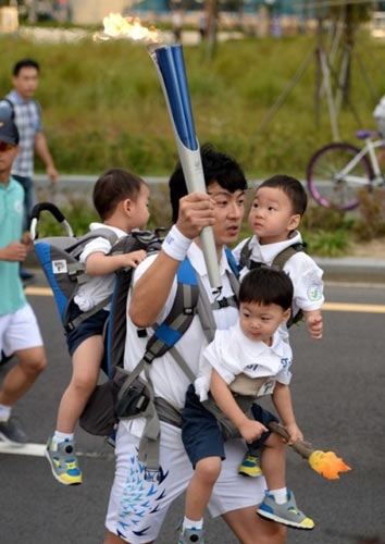 韩国男星宋一国背三胞胎传递圣火 网友:体力惊人(图)