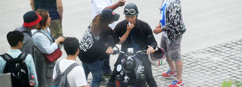 李晨烫卷发戴头盔骑电动车 路边拍戏补妆 