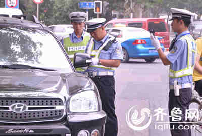 交警正在查处未按规定悬挂号牌的车辆。