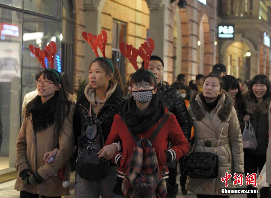 12月24日平安夜，湖北武汉楚河汉街各种圣诞灯饰流光溢彩，挤满了逛街的市民。圣诞节是西方国家一年中最重要的节日之一，近年来，圣诞购物季快速走进中国。中新社发 张畅 摄