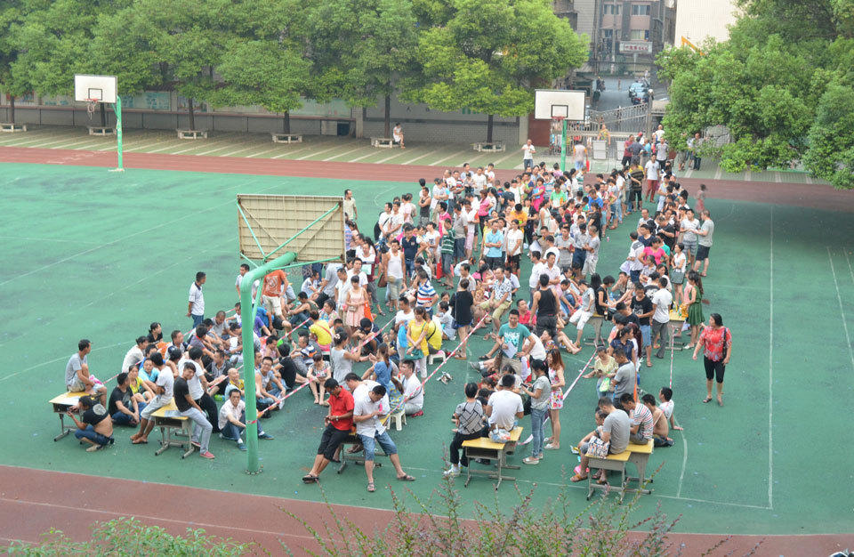 8月5日早上6点，在芦淞区樟树坪小学报名点，排队等待的家长从操场一直排到了校门口。摄影/王雅娜