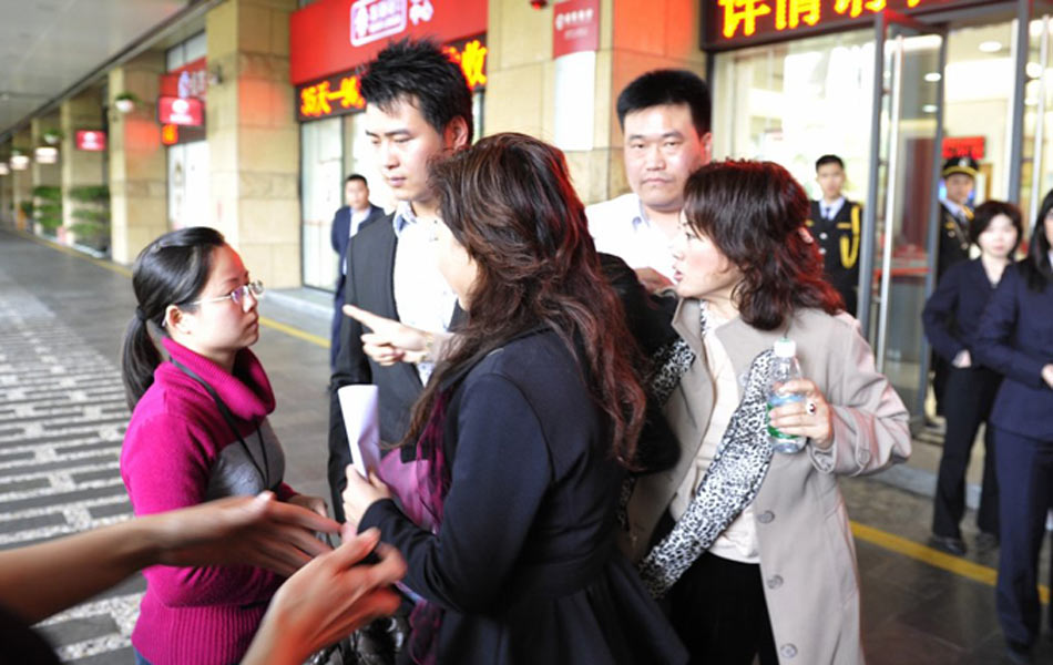 连日来，《深圳商报》对深圳怡景中心城商业发展公司涉嫌违规售铺连续作了大篇幅的报道，昨天董事长刘伟宏召开发布会解释此事。发布会结束，《深圳商报》记者秦兴梅紧跟刘伟宏，希望采访刘伟宏本人。不料刘伟宏强拉住她的胳膊，没等她站稳就挥起一拳，击中记者胸口，并扬言言：“我打你怎么了？图为2月13日，刘伟宏（右一）当众和《深圳商报》记者秦兴梅（左一）发生冲突。