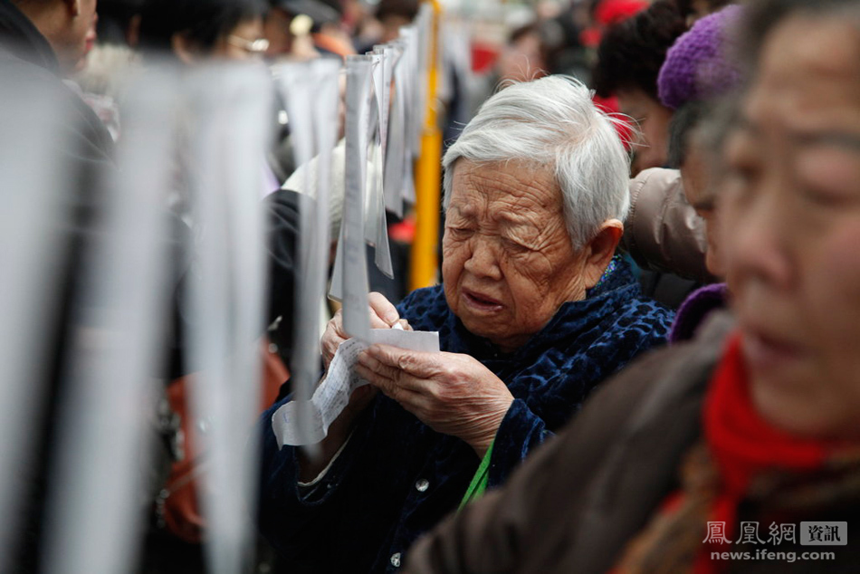 青岛,中老年人相亲会现场,一位老太仔细记录相亲资料.