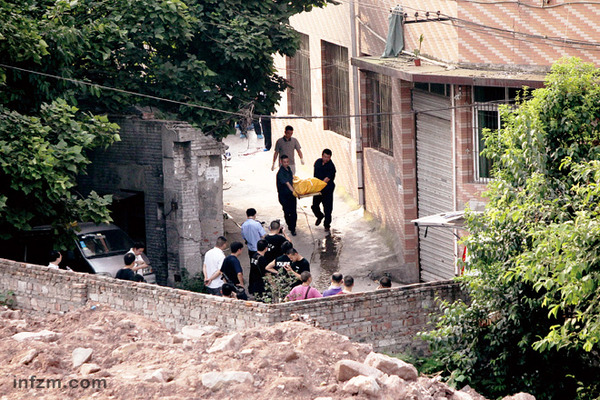 2012年8月14日，沙坪坝区童家桥，某皮鞋厂旁的一条小巷，犯罪嫌疑人周克华在这里被重庆警方击毙。警察正在将周的尸体抬离现场。 （风名/图）