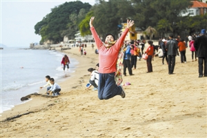 游客在鼓浪屿的沙滩上欢跳。