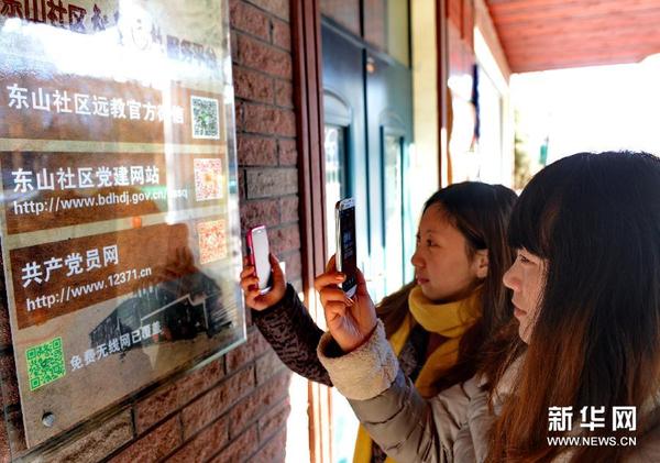 12月25日，河北秦皇岛北戴河东山社区的工作人员在用手机扫描党建教育二维码。