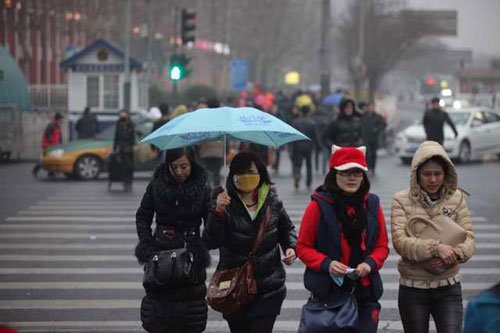 　　 华贸桥，市民撑伞在雨中行走，傍晚小雨如约而至。新京报记者薛珺摄
