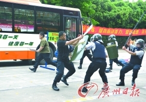 演练场景:昨日下午,广州大学城公交站突发“砍人事件”,站场保安正与“歹徒”搏斗。 记者陈安 摄