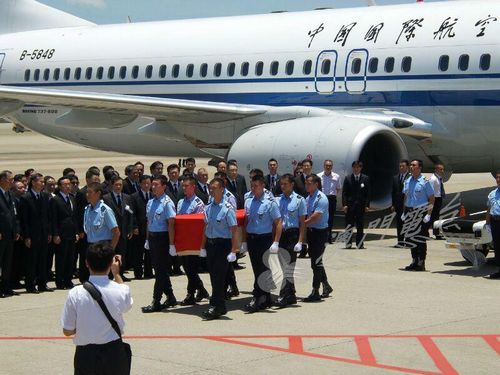 马万祺灵柩盖上国旗,由警员护送登上灵车。