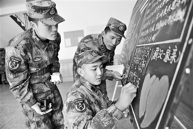 第20集团军某旅藏族战士降央丁真(前排右一)用藏文办板报,让官兵了解