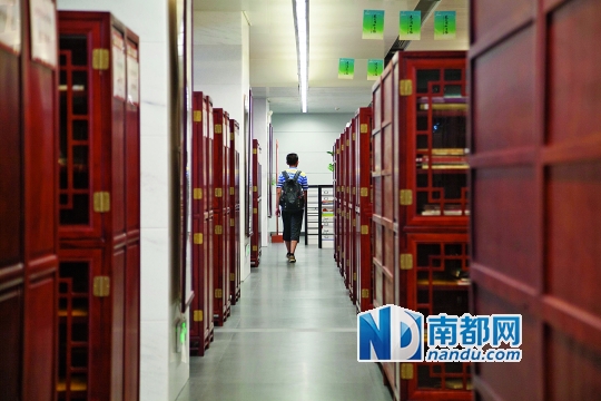 广州图书馆，读者从摆放整齐的书架间走过。