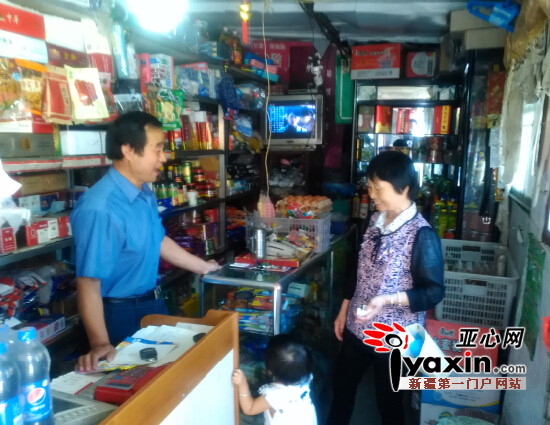 图为邻居来到张合法（左一）的商店，请他帮忙照看一会孩子。亚心网记者 肖琳 摄