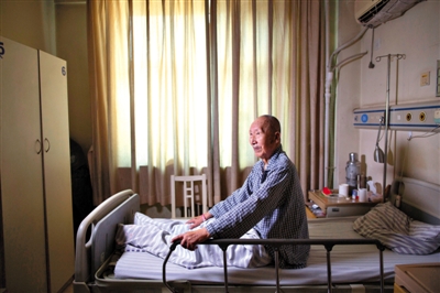 2013年3月17日，抗战老兵韩玉衡在海淀医院的病床上。今年记者去采访时，老人又是在病榻之上，仍是腰板笔直的军人坐姿。新京报资料图片/记者 侯少卿 摄