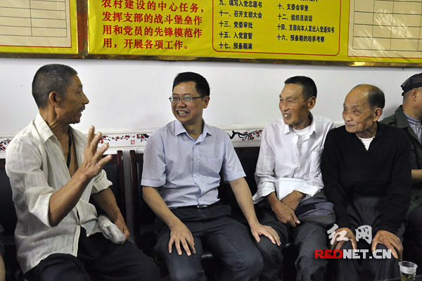 (邱初开[左二]在江垭镇农贸市场居委会与移民代表促膝而谈。)