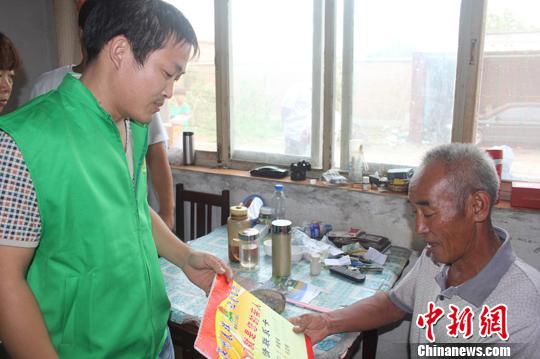 图为衡水春晖义工协会深州站的志愿者为徐文科送上亲情联系卡。 李洋 摄