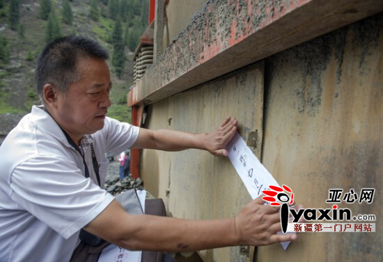 7月24日，乌县国土执法大队执法人员张建国将封条贴在一台碎砂制砂生产线上。