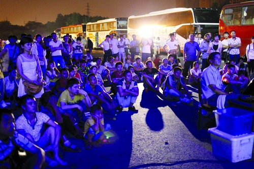 7月31日凌晨,京港澳高速长沙服务区,休息的乘客正在看露天电影。图/记者华剑