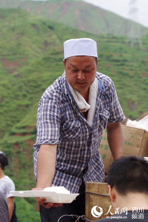 回族的大叔正在给救援者打饭。(陈永斌摄)