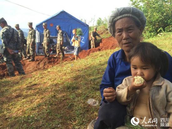 玲玲的妹妹正在吃煮玉米。