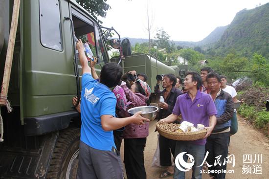 群众纷纷将食品往车上送。