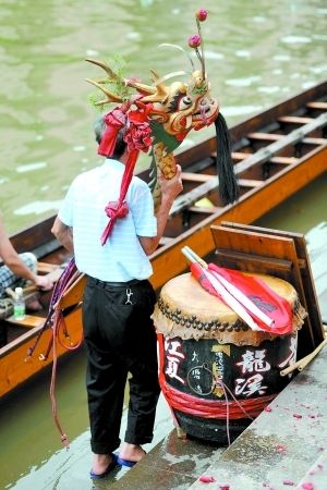 一位村民托着卸下来的龙船头准备去祠堂吃龙船饭。记者莫伟浓实习生郑凯夫 摄