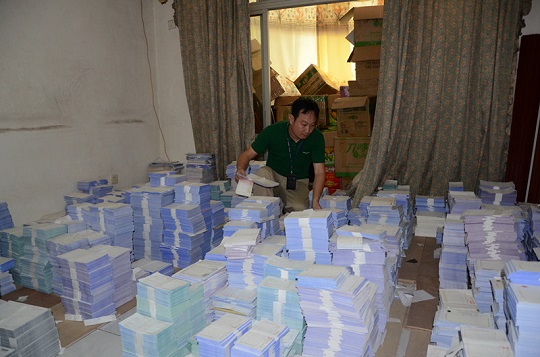 图为专案组民警正在清点现场缴获的假发票。 （惠珍 摄）