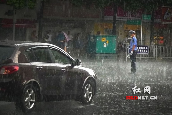 (正在雨中执勤的何建)