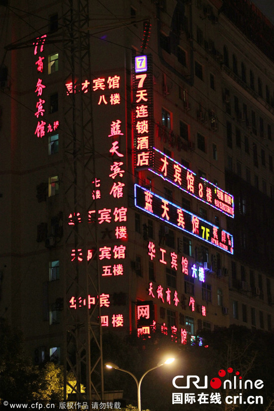 　　2014年9月17日，湖北武汉，关山口某名牌大学大门前马路对面一栋十多层的楼房里开了10多家宾馆，被网友称为“开房大厦”。图片来源:CFP