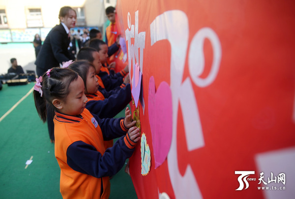 一年级的学生将自己的心愿卡贴在心愿布上