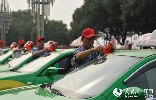 在南昌红谷滩新区会展中心广场上，出租车司机给车辆插上国旗。
