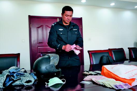 民警在展示嫌犯盗窃的财物。