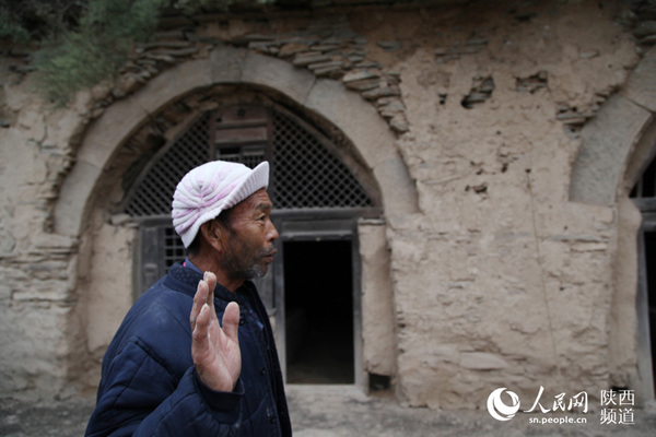 千年古窑，位于陕西延川县土岗乡小程村，古窑窑面上刻有古代胡人服饰的人物形象（门神）。据专家考证，这3孔古窑洞为匈奴人建造，至今已有1400余年。图为古窑所有者程老汉讲述古窑历史。高岗/摄