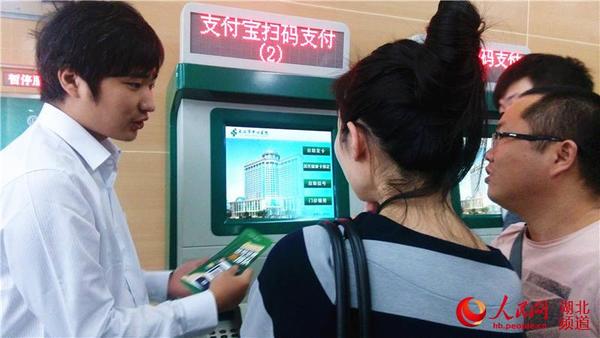 医院工作人员正在指导市民如何使用支付宝扫码支付机