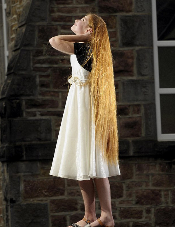 英国12岁少女凯蒂·怀特只有1.5米高,但她的头发就有约1米长。(网页截图)