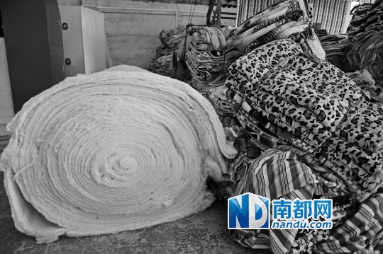 ↓半成品的化纤和成品棉被堆放在仓库的地上。南都记者 梁炜培 摄