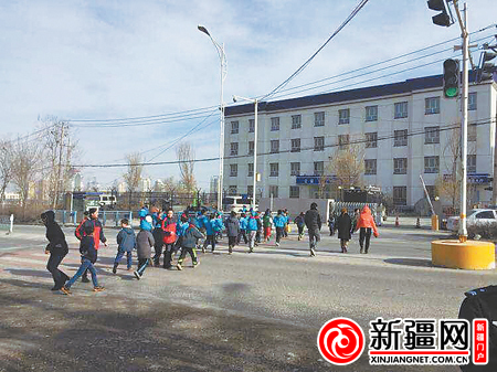 11月18日，第56小学的学生在老师的带领下过马路。