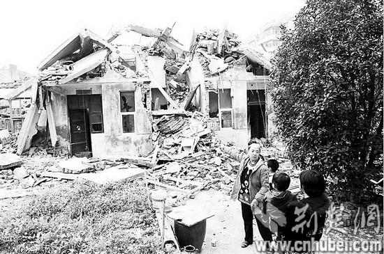 图为：孟母杨文华和家人回来看看被强拆的自家楼房