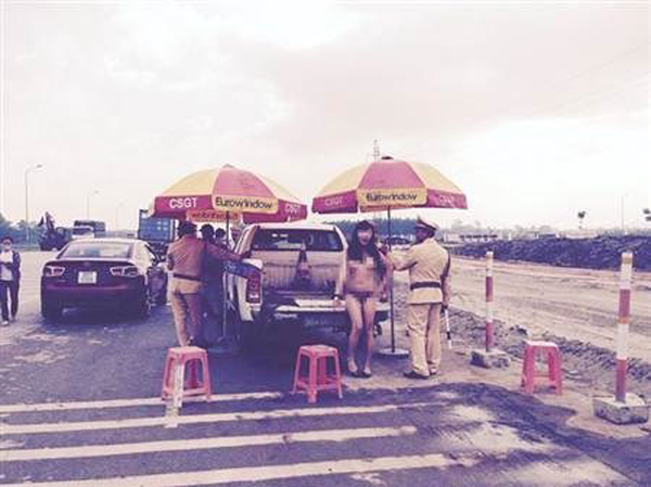 越南变性人裸体站在警车旁引围观。