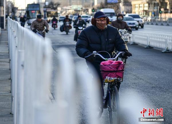 北京迎大风降温天气 市民武装出行
